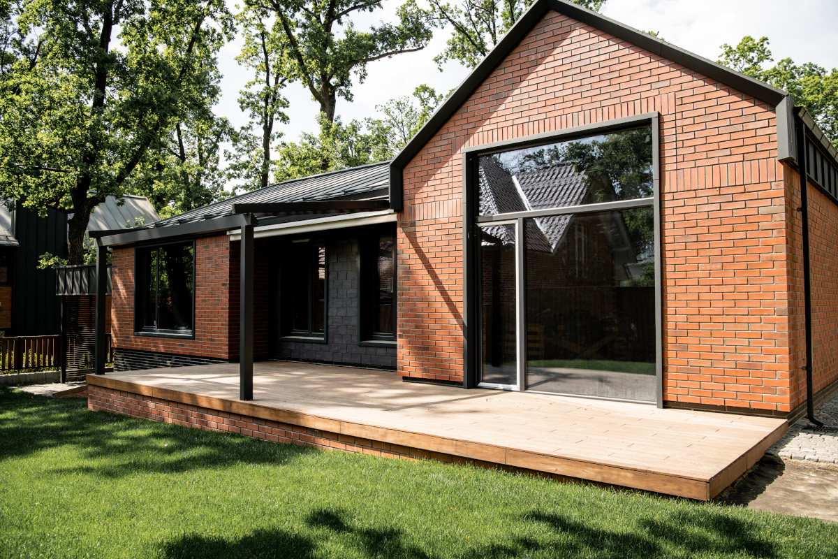 property market, brick cottage with large panoramic windows, patio, green lawn